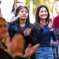 Event attendees watching stage area and clapping